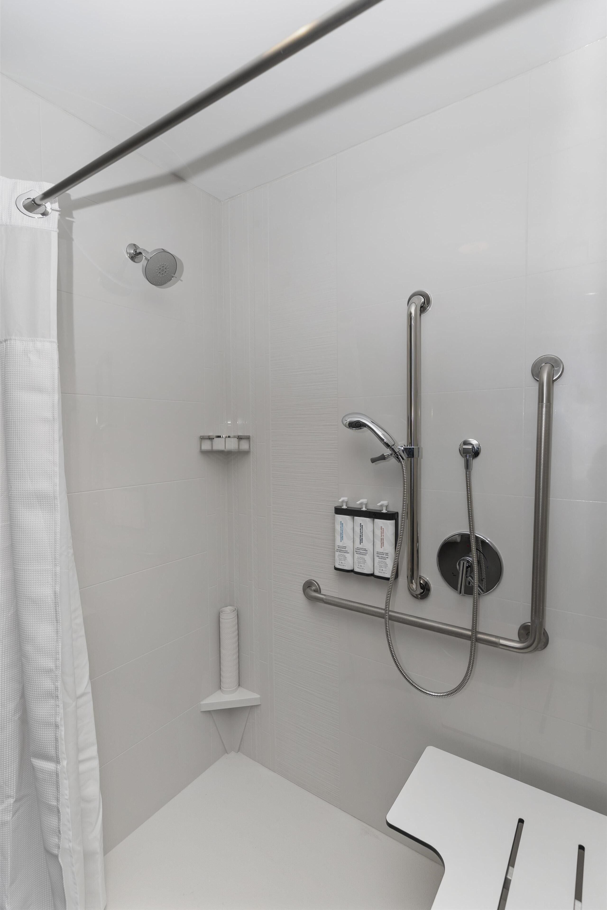 Un baño moderno con ducha, inodoro y lavamanos.
