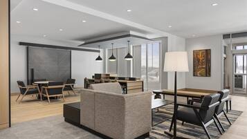 A modern interior with a sofa, dining table, chairs, and pendant lighting.