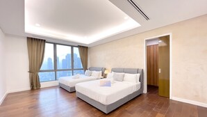 A modern hotel room with two beds, a city view, and a wooden floor. - Neu Suites Horizon View Apartments (Kuala Lumpur)