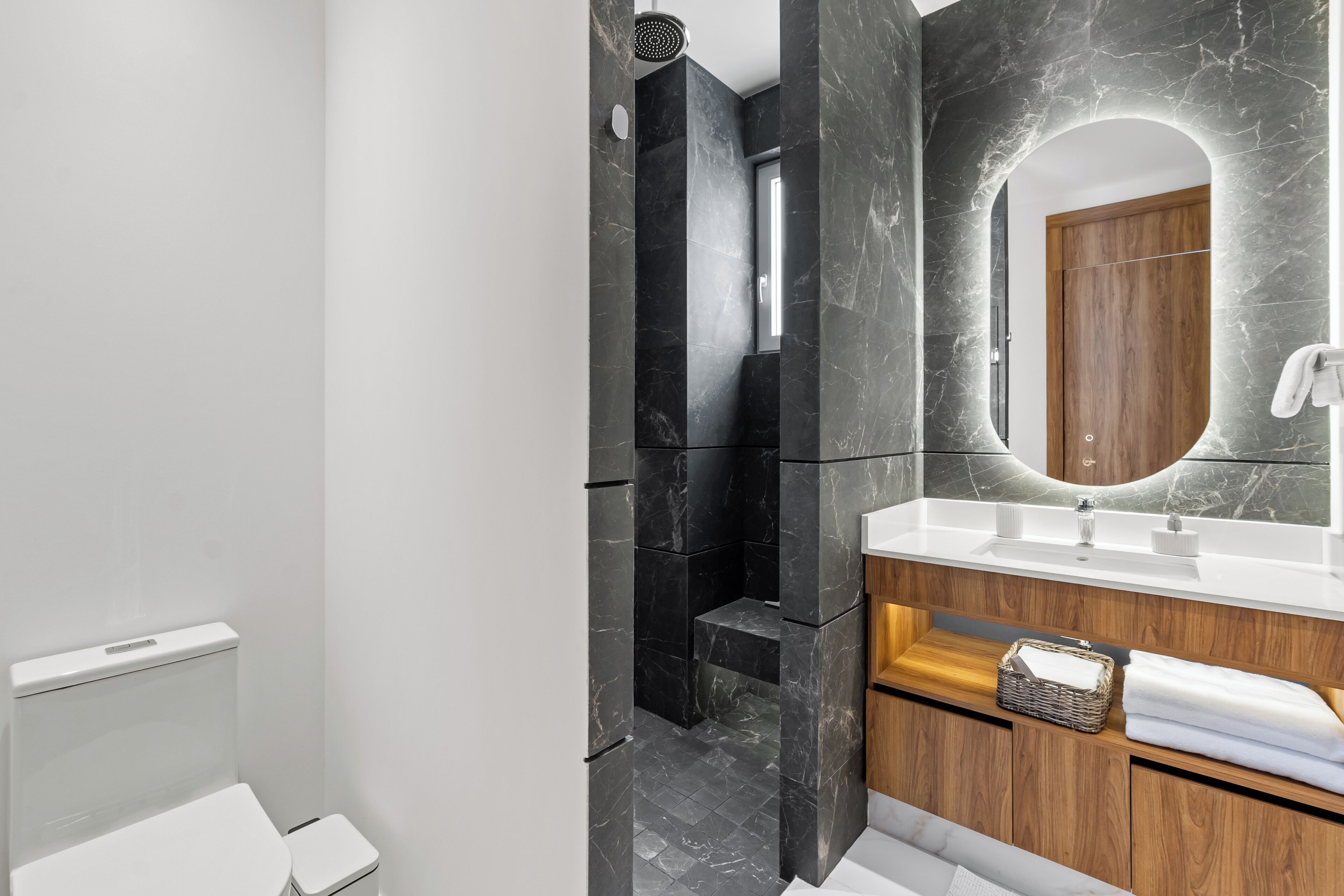 Un baño moderno con inodoro, lavabo y ducha.