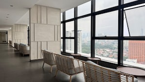 A modern hotel lobby with high ceilings, large windows, and a city view. - The Pano Green Sentul Park (Kuala Lumpur)