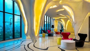 Un interior modern amb un sostre corbat, finestres grans i mobles contemporanis.