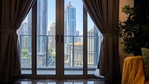 A room with a large window offering a view of tall buildings. - Royce Residence KLCC Skyview Apartments (Kuala Lumpur)