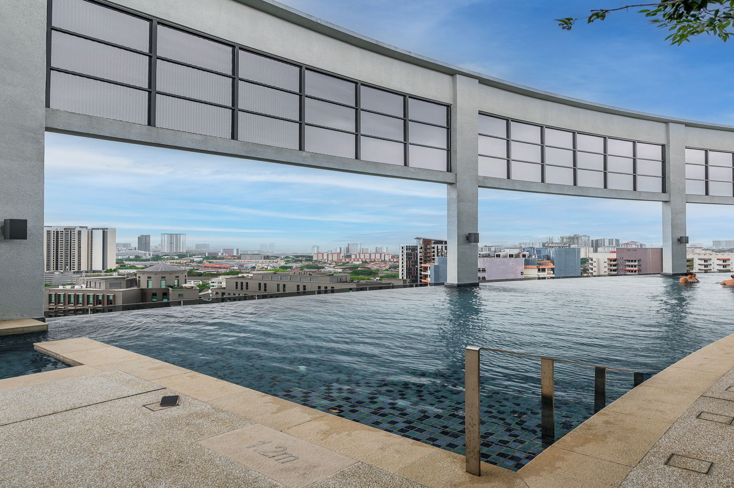 A rooftop infinity pool with a city view, large windows, and a modern architectural design.