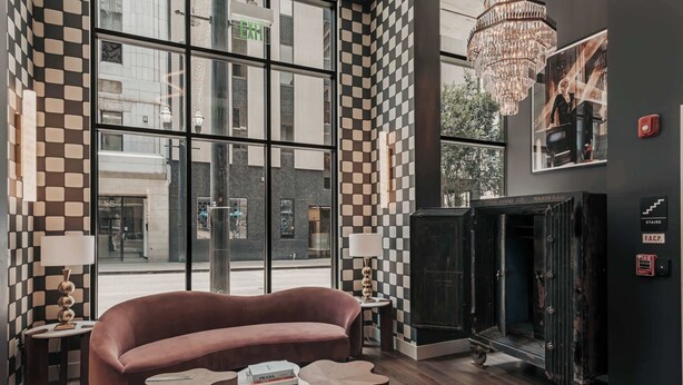 A modern interior with a large window, a checkered wall pattern, a fireplace, and a chandelier. - Starr Piano: Roxie Suite –  Walk to Broadway! (Nashville)