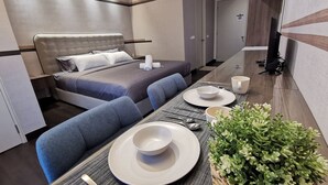 A modern hotel room with a bed, a dining area, and a TV. - 28 Boulevard Residence KLCC Skyview (Ampang)
