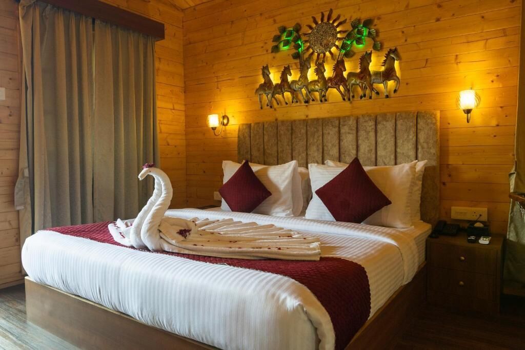 Una habitación con paneles de madera, una cama, dos lámparas fijadas a la pared y un adorno decorativo sobre la cama.