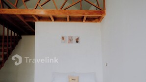Une chambre à coucher avec un cadre de lit en bois, du linge de lit blanc et une décoration murale simple.