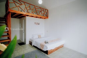 Un dormitorio con una cama nido de madera, una cama individual y una puerta pequeña.