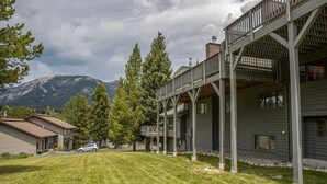 Un bâtiment à deux étages, doté d’un porche abrité et surplombant un paysage montagneux.