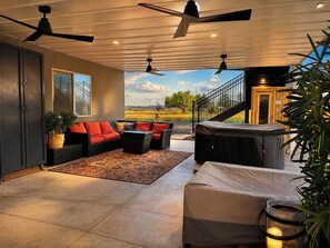 A spacious living area with a sofa set, a coffee table, and a grill.