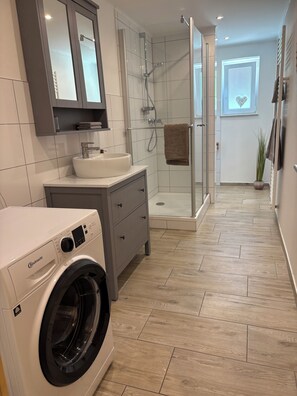 Een douche, een haardroger, handdoeken, toiletpapier