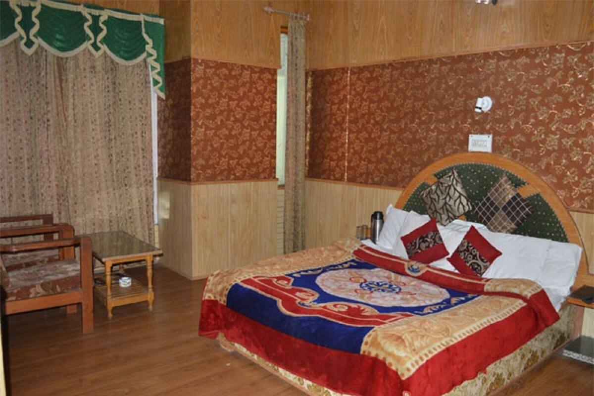 A room with a wooden bed, a small table, and a chair.