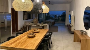 A modern kitchen with a wooden table, black chairs, and woven pendant lights. - A3 - Sea view - Soleil des Canonniers (Trou-aux-Biches)