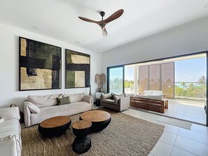 A modern living room with a sofa, coffee table, and artwork on the wall. - A3 - Ocean View - Soleil des Canonniers (Trou-aux-Biches)