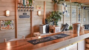 Zona de bar con paredes y mostrador de madera, y un letrero que dice "Adnams Ghost Ship".