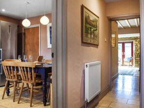 Un coin repas avec des chaises en bois, une table et un tableau encadré au mur.