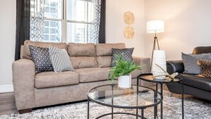 Ein Wohnzimmer mit einer Couch, einem Couchtisch, einer Lampe und einem Kissen mit Leopardenmuster.