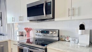 A modern kitchen with stainless steel appliances, including a microwave, oven, and coffee maker.