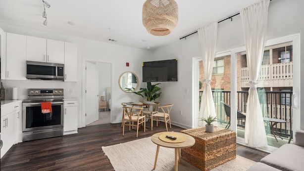A modern apartment with a kitchen, dining area, and balcony.