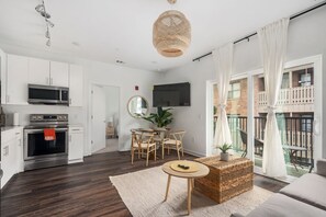 Een modern appartement met keuken, eethoek en balkon.