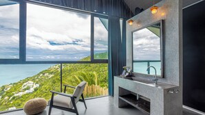 A modern bathroom with a large window, a stone sink, and a chair. - Hin Butik Villa 4BR Private Seaview (Koh Samui)