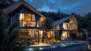 A modern two-story house with a swimming pool, large windows, and outdoor seating. - Hin Butik Villa 4BR Private Seaview (Koh Samui)