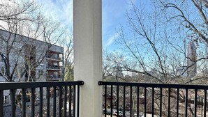 A balcony with a view of a parking area and buildings.