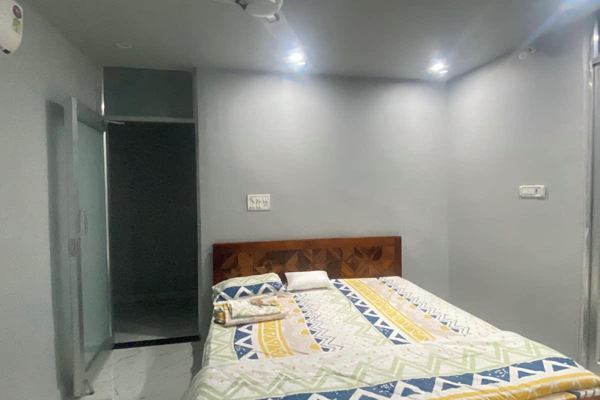 A bedroom with a bed, a wardrobe, and a door leading to a bathroom.