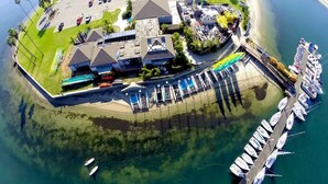 An aerial view of a coastal property with a marina, a parking lot, and buildings with solar panels. - Boho Bliss | Mission Beach Retreat w/ Surfboards (San Diego)