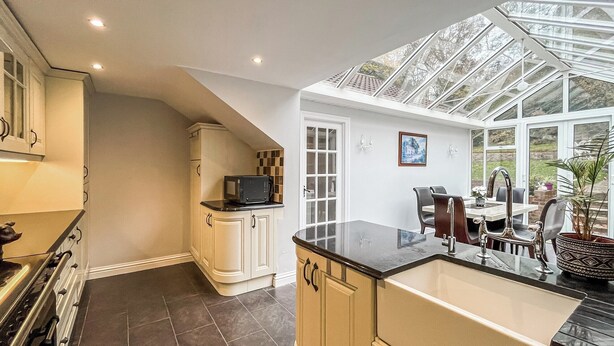 A kitchen with a large island, a microwave, and a dining area with a table and chairs.