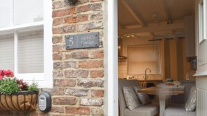 Een gevel van baksteen met een bord waarop staat: Taylor's Cottage.