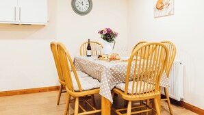A dining area with a table set for two, a clock on the wall, and a framed picture of a fox. - 3 bedroom accommodation in near Gatehouse of Fleet (near Gatehouse of Fleet)