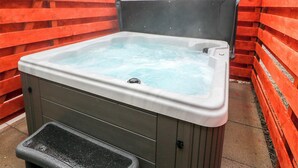 A hot tub with a pump and a control panel, surrounded by red wooden walls. - 3 bedroom accommodation in near Gatehouse of Fleet (near Gatehouse of Fleet)