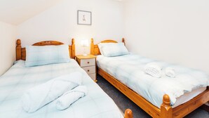 A bedroom with two wooden beds, a nightstand, a small table, a framed picture, and a skylight. - 3 bedroom accommodation in near Gatehouse of Fleet (near Gatehouse of Fleet)