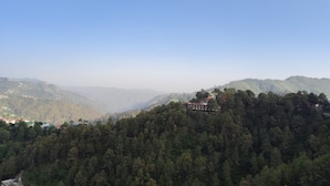 A hotel nestled in a forested mountain area with a clear view of the surrounding landscape. - OnlyStay Silicon Inn Shimla (Shimla)