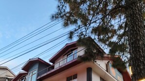 A two-story residential building with a balcony, a porch with a railing, and a staircase leading to the entrance. - OnlyStay Silicon Inn Shimla (Shimla)