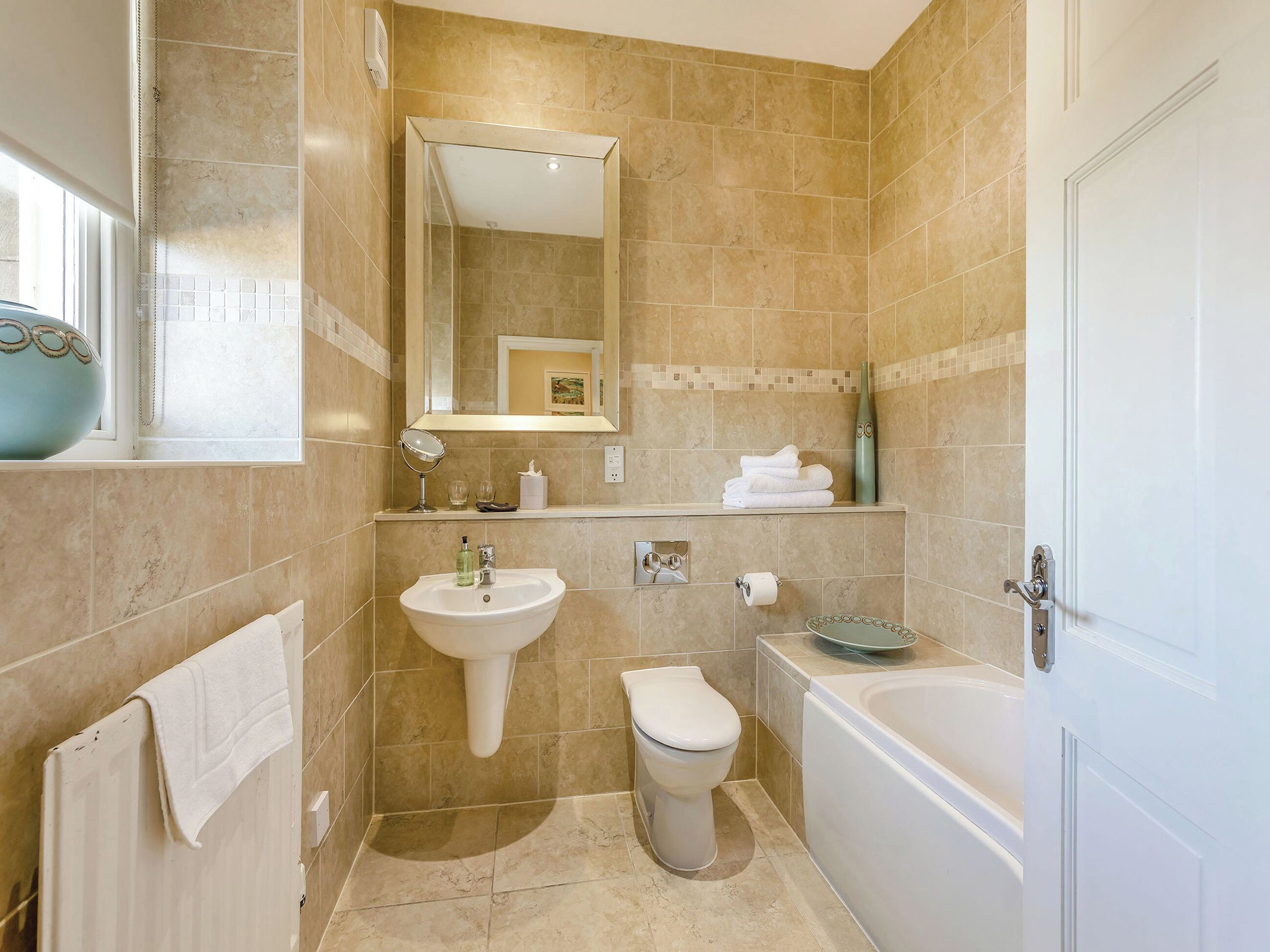 Une salle de bain équipée d’un lavabo, de toilettes, d’une baignoire et d’un miroir.