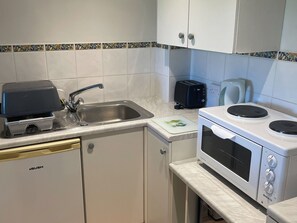 Une cuisine équipée d’un évier, d’un grille-pain, d’un four à micro-ondes et d’un lave-vaisselle.