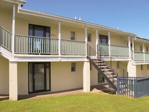 A multi-story building with balconies, a staircase, and a door.