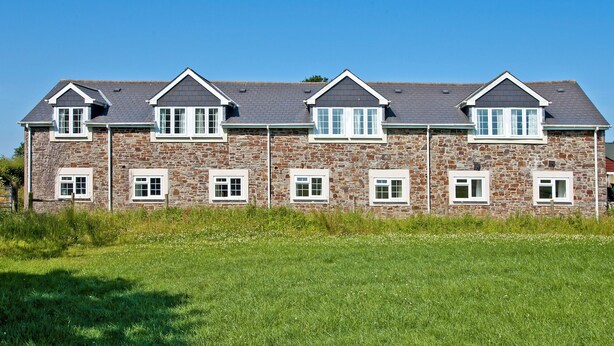 A large stone building with multiple windows and a sloped roof. - Chaffinch Apartment - UK49307 (Woolfardisworthy, Clovelly)