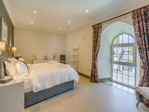 A bedroom with a large bed, bedside tables, a chair, a window with curtains, and a view of the outside. - 5 bedroom accommodation in Duns (Duns)