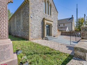 A stone church with a memorial plaque, a gravel pathway, and a small garden area. - 5 bedroom accommodation in Duns (Duns)