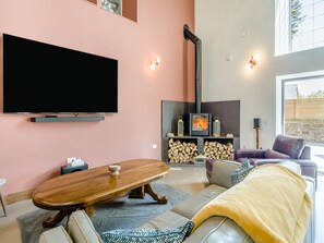 A modern living room with a flat-screen TV, a fireplace, a sofa, and a coffee table. - 5 bedroom accommodation in Duns (Duns)