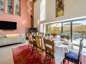 A dining area with a table set for six, wooden chairs, and a red patterned rug. - 5 bedroom accommodation in Duns (Duns)
