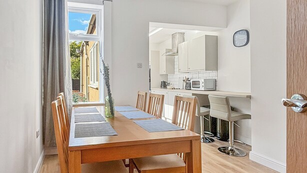 A modern kitchen with white cabinets and a microwave.