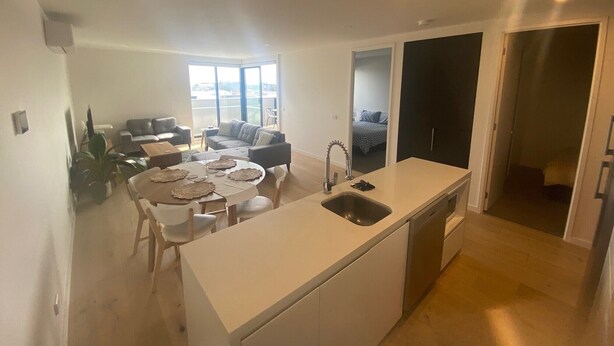 Een modern appartement met keuken, eethoek en zithoek.