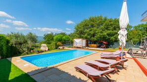 Une piscine avec des chaises longues et un espace aménagé autour.