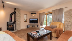 A living room with a fireplace, a television, a sofa, and a coffee table.