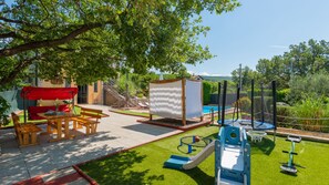 A patio area with a table and chairs, a play structure, and a pool. - Villa Ema - Makarska by Villas Guide (Donji Vinjani)
